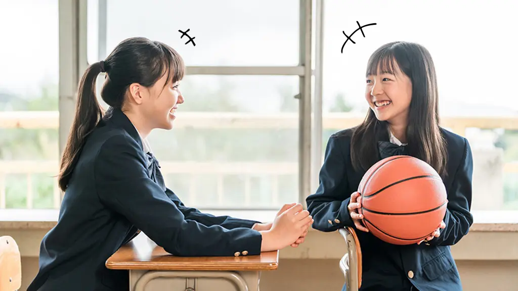 バスケットボールを持った女子学生が友達と楽しそうに話している