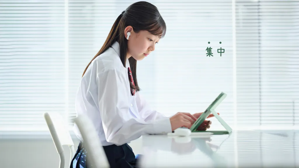 タブレットを用いてオンライン授業を受けている女子学生