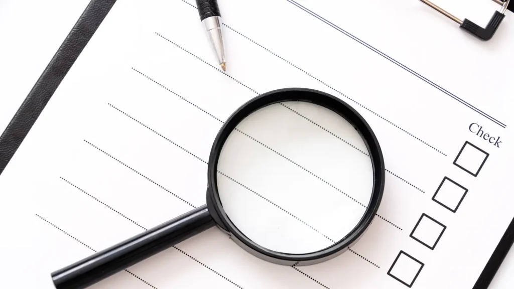 チェックリストと虫眼鏡とペン