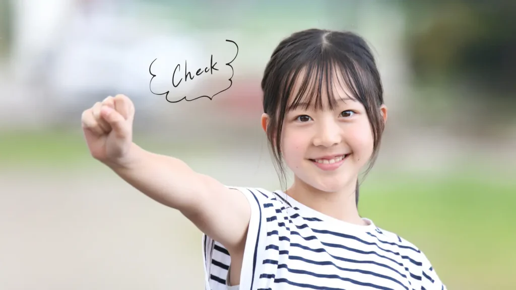 笑顔で拳を突き出している小学生