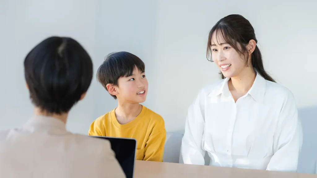 小学生と保護者と家庭教師が話し合っている